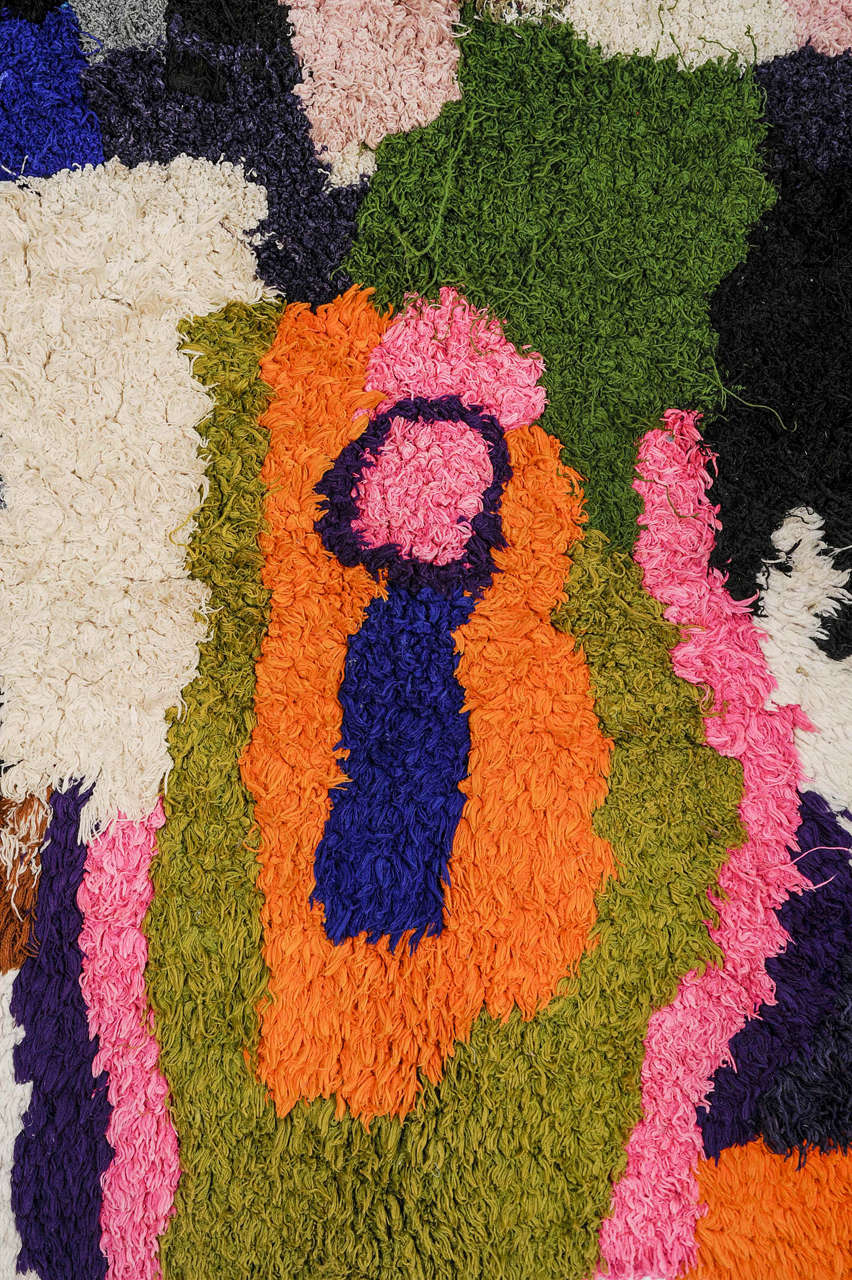 Woven on a plastic foundation utilizing recycled yarns of various type, ranging from cotton to lurex, this represents 'art brut' within the domain of the textile arts. Weavings such as this are the product of illiterate Berber people living at the